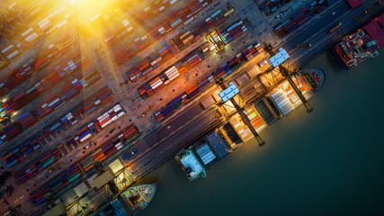 Logistics and transportation of Container Cargo ship and Cargo plane with working crane bridge in shipyard at sunrise, logistic import export and transport industry background