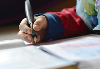 Boy is writing in his notebook doing home work for school