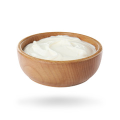 Wooden bowl with delicious sour cream on white background