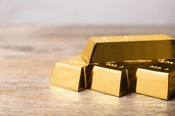 Precious shiny gold bars on wooden table