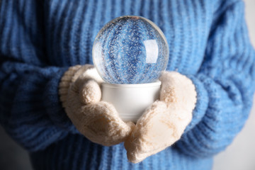 Woman holding magical empty snow globe, closeup