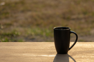 Black hot coffee with morning light on wooden table