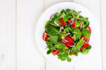 Concept of weight loss, healthy lifestyle. Light salad from fresh vegetables and herbs