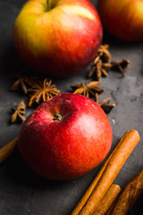 Apples with cinnamon and other spices on rustic wooden background. Selective focus.elective focus.