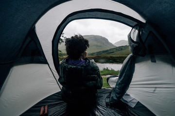 Woman sitting in a tent while it's raining © Rawpixel.com