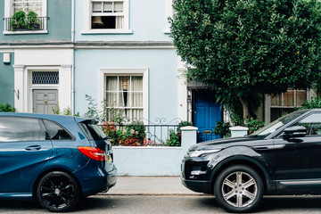 Two parked cars in front of an apartment entrance - Powered by Adobe