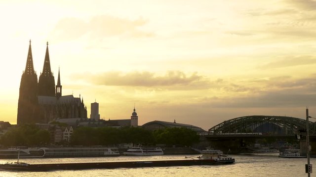 4K video clip of sunset behind Cologne Cathedral with tanker ship sailing on the River Rhine, Germany