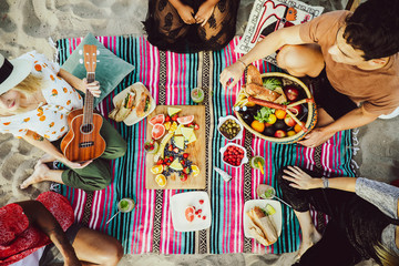 Diverse friends enjoying a beach picnic