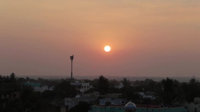 A static shot of sun in which a bird passby at an distance.