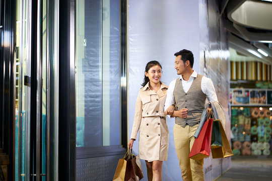 young asian couple walking in shopping mall