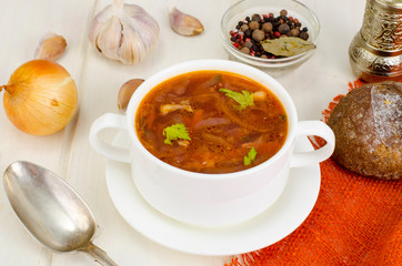 Soup with vegetables on white wooden surface