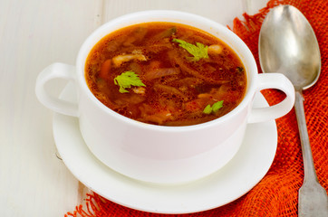 Soup with vegetables on white wooden surface