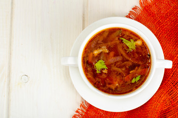 Soup with vegetables on white wooden surface