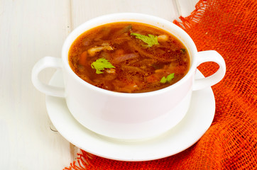 Soup with vegetables on white wooden surface