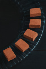 Soft chocolates in cocoa powder on a black background with copy space. Japanese gourmet chocolate close-up