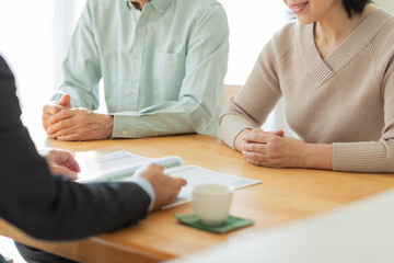 中年夫婦に説明するビジネスマン