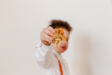 pancake in the hands of a child in the foreground, blurred background