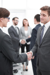 Two businessmen handshaking, congratulating on promotion.