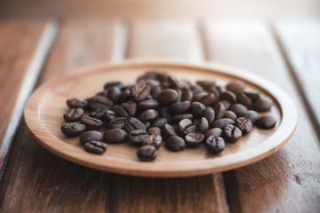 Closeup image of coffee beans on wooden saucer on the table