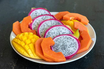Tropical fruits assortment on a plate, close up