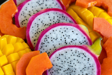 Tropical fruits assortment on a plate, close up