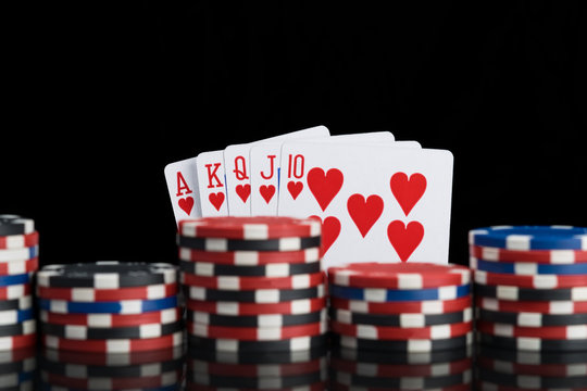 many different levels of poker chips on the background of a winning combination of cards