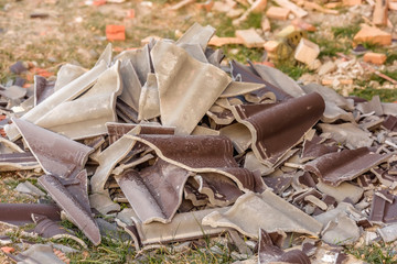 Broken ceramic tiles. Building. Material for the roof of the house. Pieces of brown tile lying on...