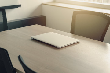 Laptop on table in empty corporate conference room