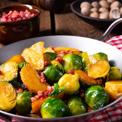 Brussels sprouts potato pan with bacon in rustic style