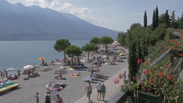 Panning shot overlooking beach and lake in Limone sul Garda, Lake Garda, Lombardia, Italy, Europe