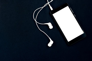 Smartphone and headphones on a black background.  Top view, space for text