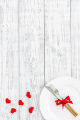 Dating in the restaurant on Valentine's day. Decorated dishes on white wooden background top view copy space