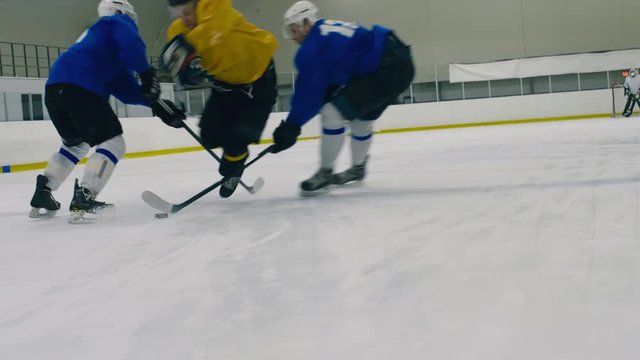 Tracking shot of ice hockey attack during match whereby one player bumping into his rival's stick and falling down