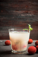 Old fahioned lychee cocktail on the rustic background. Selective focus. Shallow depth of field. 