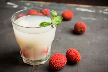 Old fahioned lychee cocktail on the rustic background. Selective focus. Shallow depth of field. 