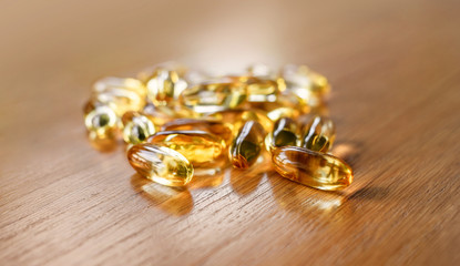 fish oil capsules on wooden table