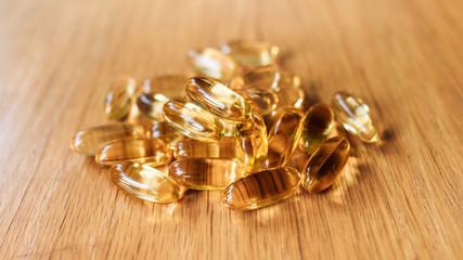 fish oil capsules on wooden table