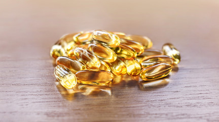 fish oil capsules on wooden table