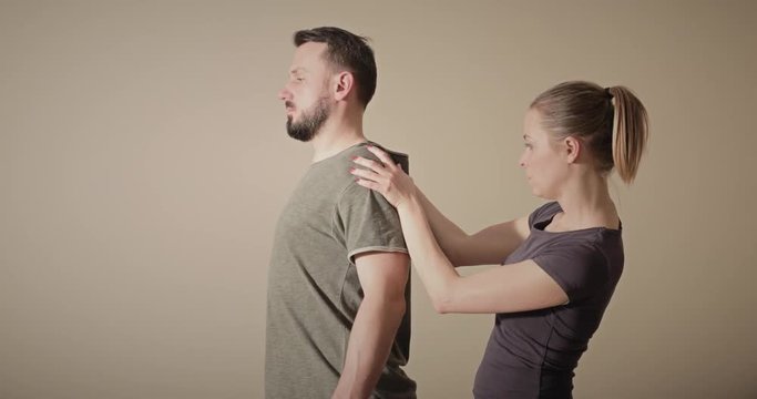 Female chiropractor doing tests and assessing a male patient