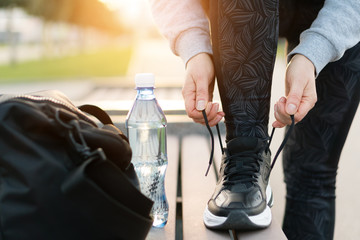 Shot of athletic woman tying she is shoelaces before a run.
