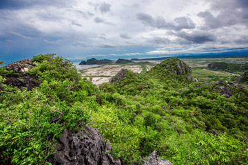Panorama scenery on the top of a high mountain, overlooking the trees, the sea, and the wind...