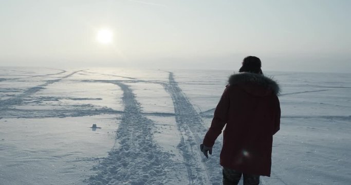 Young traveller goes through a blizzard at beautiful sunset. Polar expedition