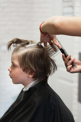 Fototapeta premium A young boy gets a haircut in a children's hairdresser