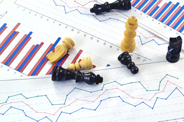 Photo of chess pieces with graphs and diagrams