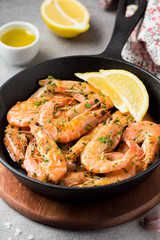 Fried shrimps in shell with parsley, coriander, garlic and oil in pan. Delicious Mediterranean cuisine, vegetarian food, healthy protein