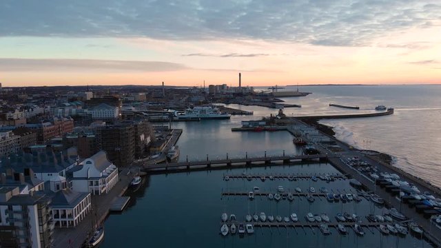 Aerial of Norra Hamnen Helsingborg, Sweden during sunset in winter going forwards towards the Forsea electrical ferry in the Harbor above the famous bridge Kvickbron.