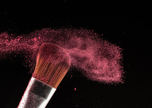 Close up powder splash and brush for makeup artist or beauty blogger in black background