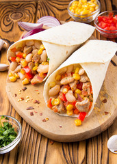Burrito in tartilla with meat, vegetables, white beans, red pepper, corn. Delicious lunch, Mexican food, homemade snack