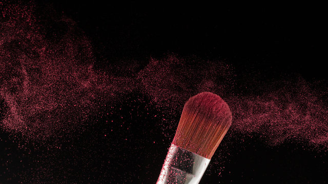 Close up powder splash and brush for makeup artist or beauty blogger in black background