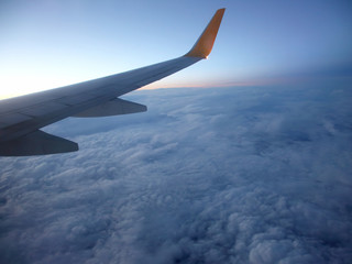 Obraz premium The wing of an airplane above the clouds